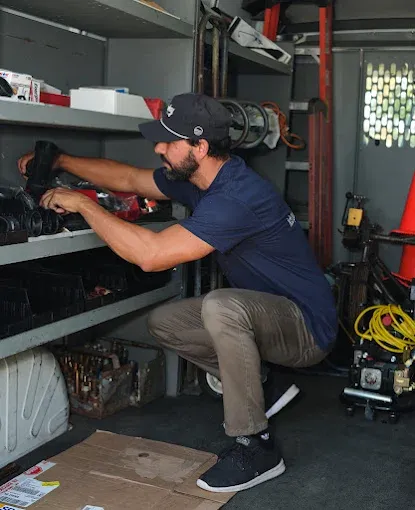 KCB Plumbing technician grabbing equipment from service van